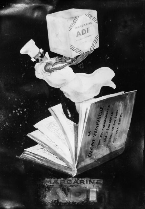 1932 - Un cuisinier sort d'un livre de cuisine en portant un paquet de margarine.