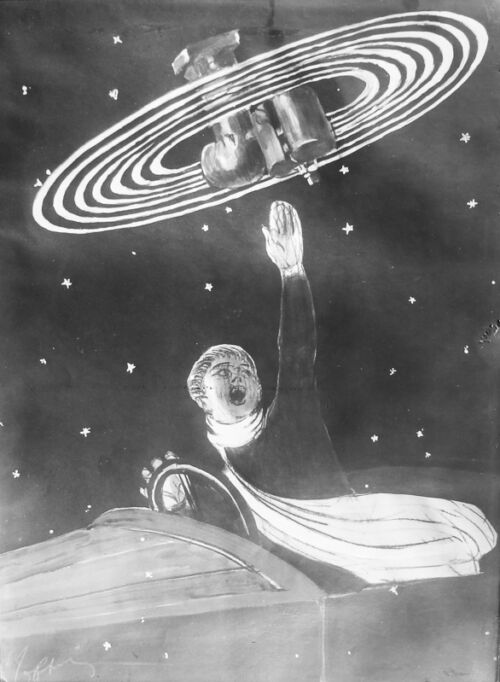 1924 - Un automobiliste dans sa voiture montre au-dessus de sa tête le merveilleux carburateur qui équipe sa voiture.